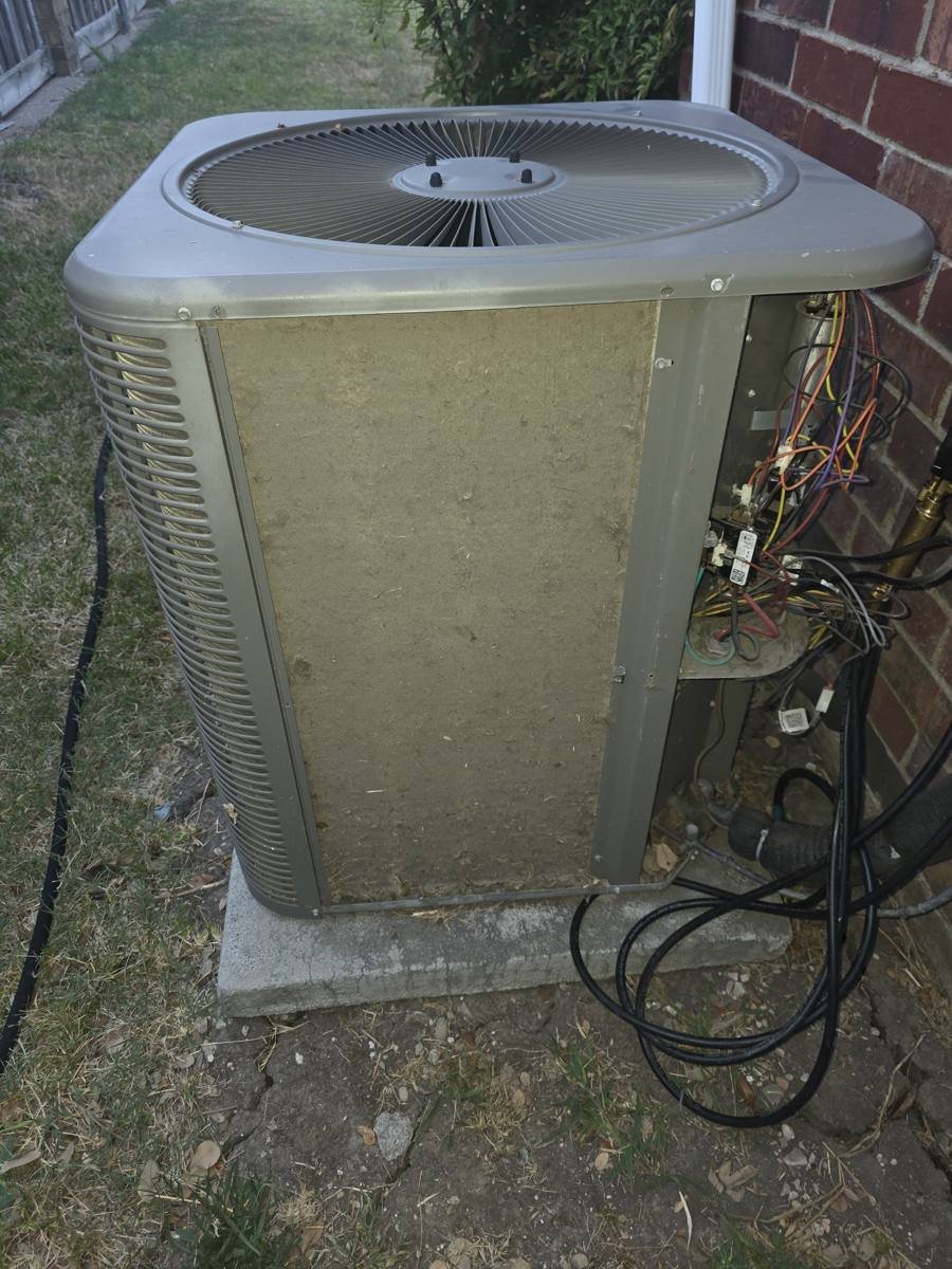 Dirty, dust-caked condenser coil on an outdoor AC unit in Richardson, TX before cleaning